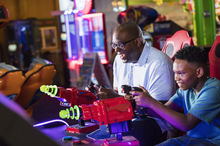 Father and son playing arcade game at Coral Beach